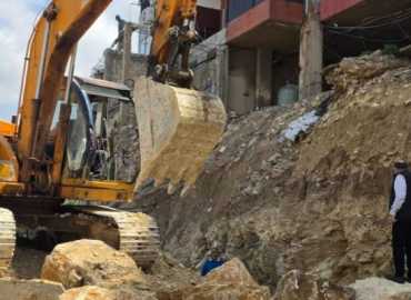 بدء إعادة بناء الحائط المنهار في العمروسية بعد إزالة التعديات