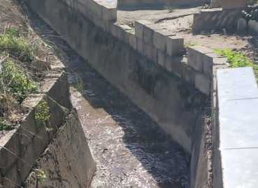 بلدية معروب تواصل أعمال تنظيف أقنية تصريف المياه قرب المقبرة