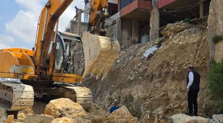 بدء إعادة بناء الحائط المنهار في العمروسية بعد إزالة التعديات